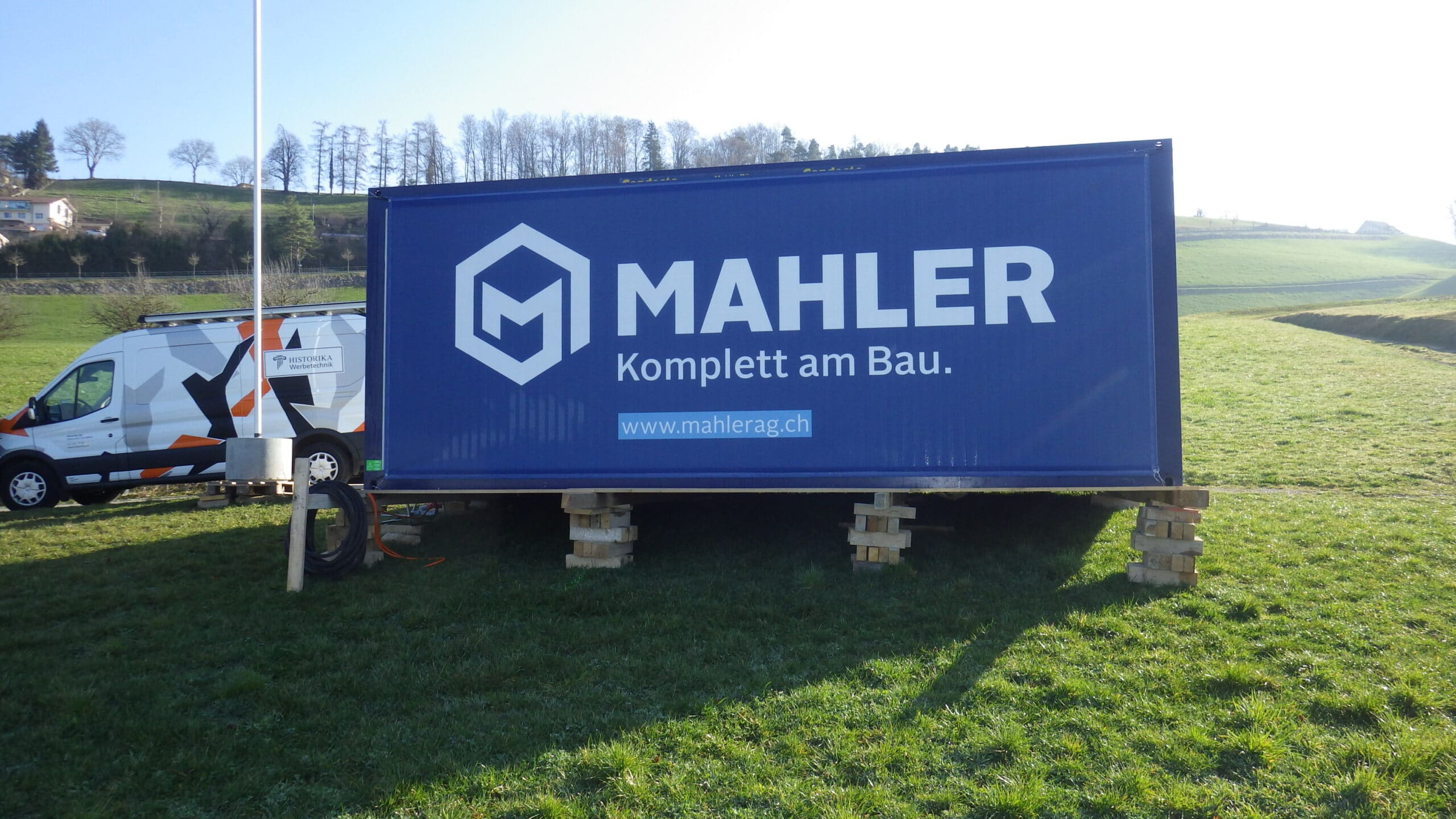 Baucontainer werden mit Werbeblachen von Historika zum Botschafter